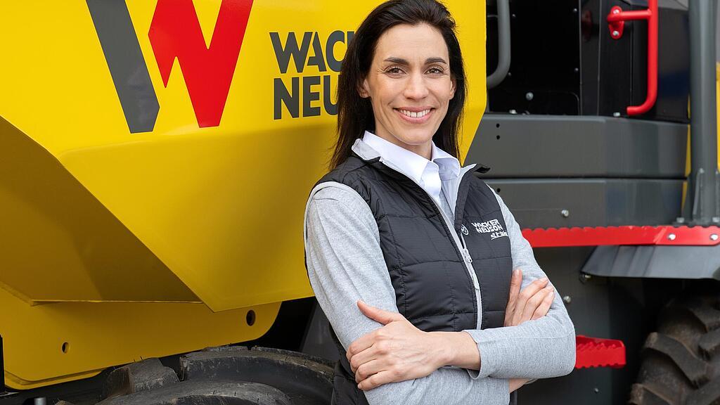 WN_PGR_image_service_04.jpg Wacker Neuson employee standing and smiling with arms folded in front of a Wacker Neuson wheel dumper.