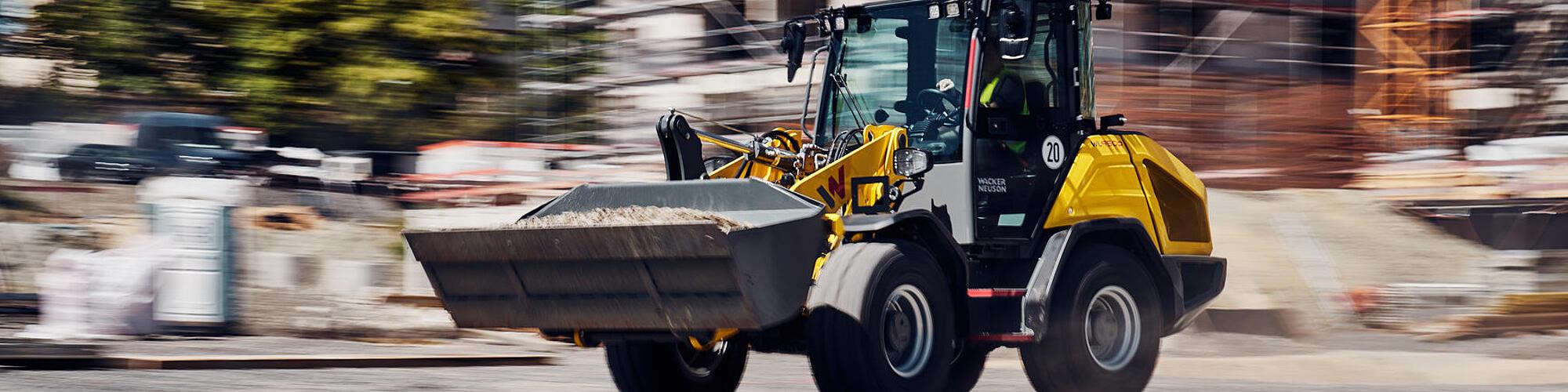 La chargeuse sur pneus haute performance Wacker Neuson WL950p roule à vive allure sur un chantier.