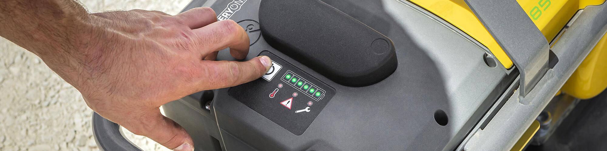 man pushes button on battery