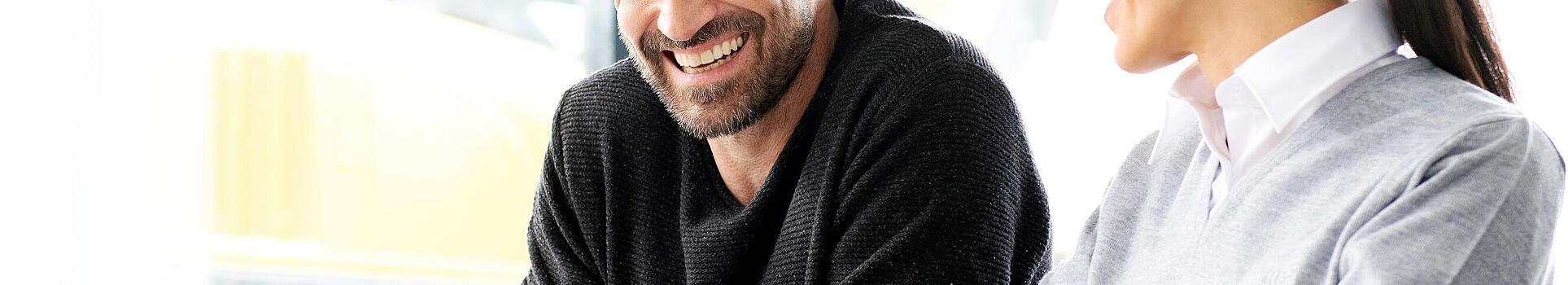 Wacker Neuson customer sitting with Wacker Neuson salesperson in front of a laptop while being advised.