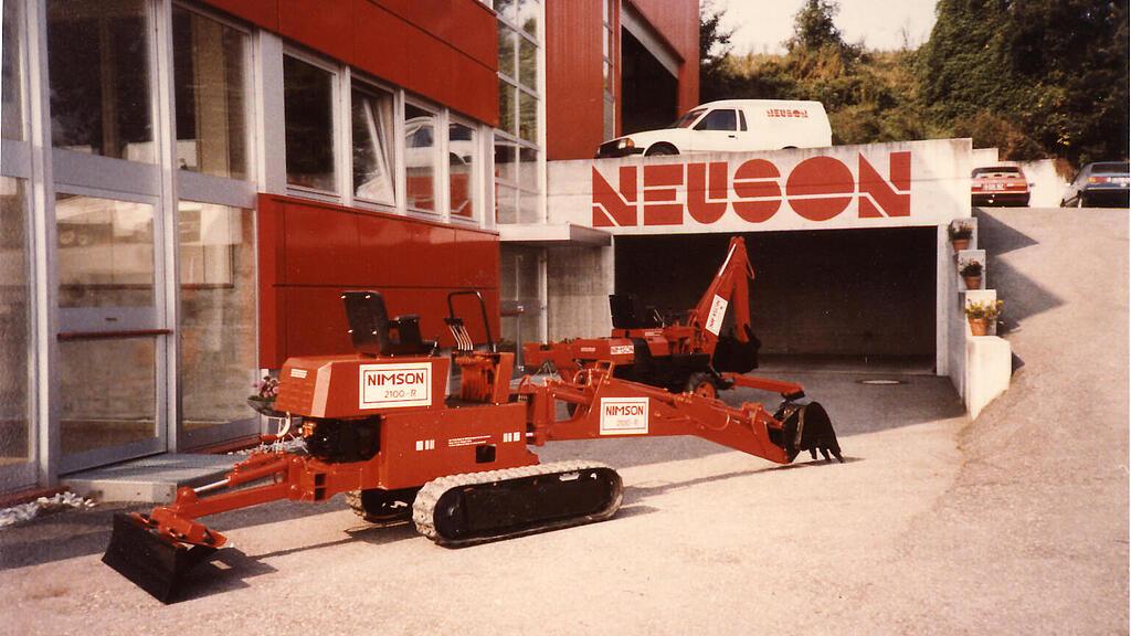 Machine de construction Neuson devant la Neuson Hydraulik GmbH récemment fondée.