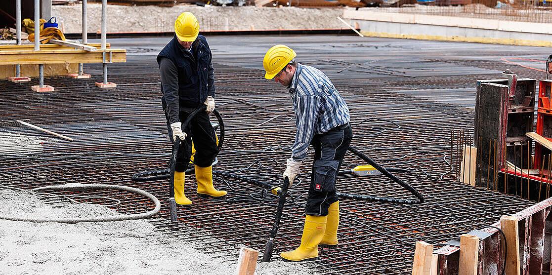 two workers consolidate concrete with Wacker Neuson internal vibrators
