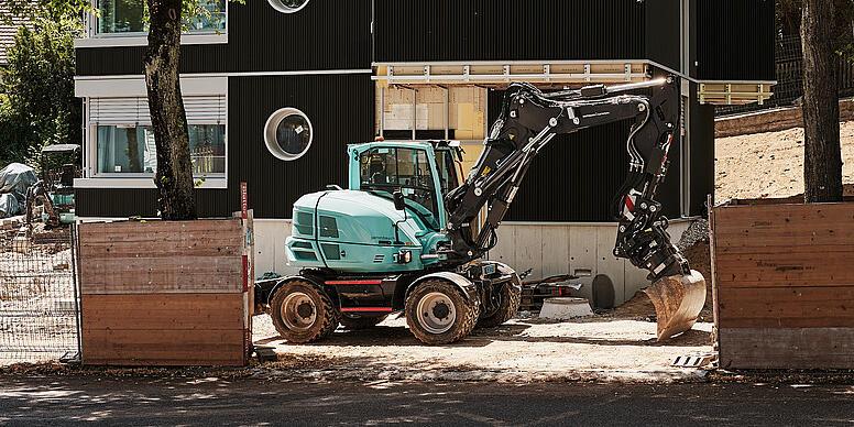 excavtor standing in front of house at a construction site